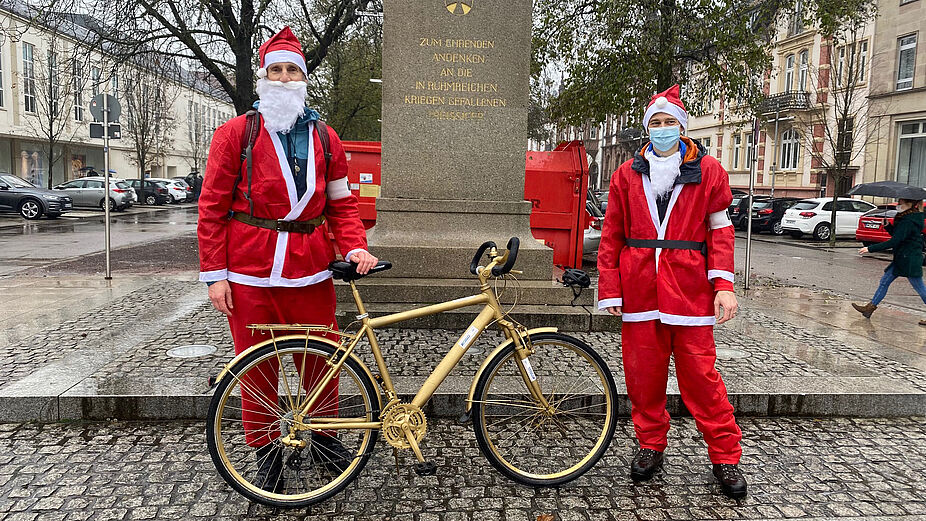 Weihnachtsmänner mit Goldenem Fahrrad Weihnachtsmänner mit Goldenem Fahrrad