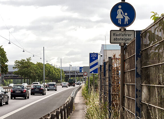 Radweg entlang der Autobahn mit Beschilderung „Radfahrer absteigen“